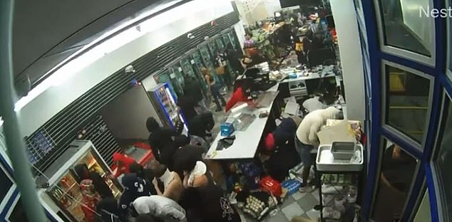 A massive mob storms an Oakland gas station after a car crashes into the glass, breaking it.