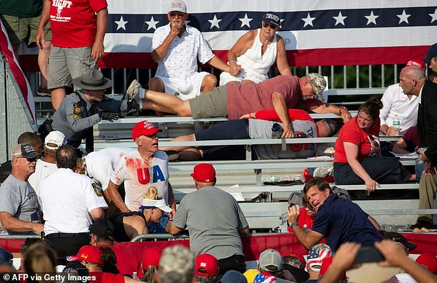 Bystanders are seen after the shooting. The man in the blood-spattered white T-shirt is an emergency room doctor who told CBS News he tried to help a bystander who was killed in the shooting. The dead bystander was on the ground just behind the man in the blood-spattered white T-shirt.