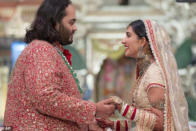 Anant Ambani, left, son of billionaire Mukesh Ambani, holds the hand of Radhika Merchant during their wedding ceremony at the Jio World Convention Centre in Mumbai, India, on Friday.