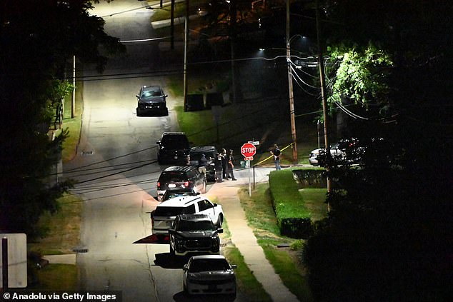 Officers stand guard outside a cordon in Bethel Park as police search an address registered to Crooks