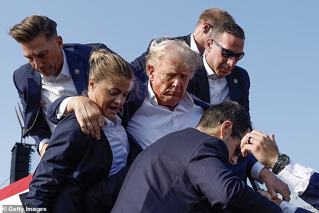 Trump was seen surrounded by Secret Service agents after the incident as he was rushed to hospital with blood running down his face.