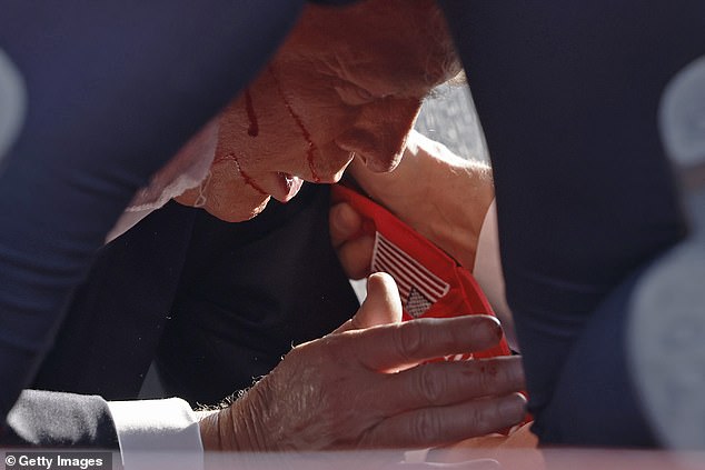 Trump had blood running down his cheeks as Secret Service agents placed him on the ground.