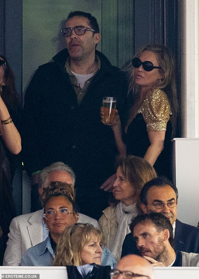 She was holding a beer while watching the concert.