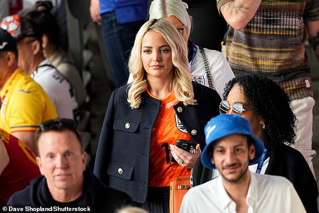 Pictured: Jordan Pickford's wife Megan Davison, seen arriving in an orange England shirt and navy blazer.