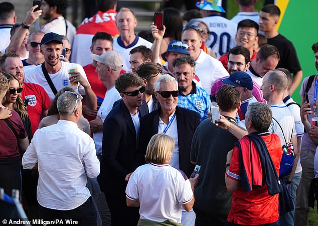 Radio presenter Roman Kemp and his musician and actor father Martin are surrounded by England fans as they arrive.