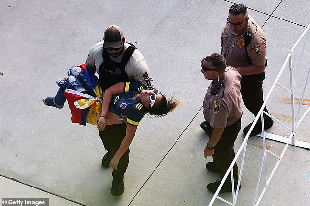 A police officer carries an unconscious fan at Hard Rock Stadium in Miami