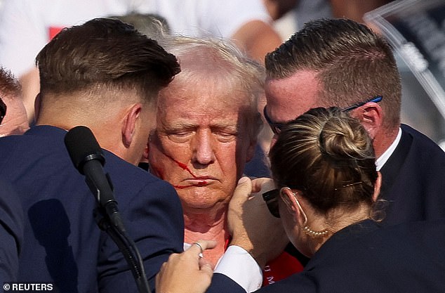 Trump is seen surrounded by Secret Service agents moments after the shooting. He raised his fist to indicate he was OK in an image that has since gone viral around the world.