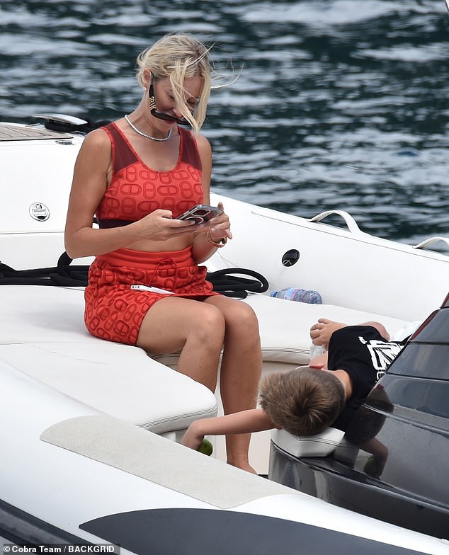 The blonde beauty was spotted taking photos of her son Hunter aboard a smaller boat.