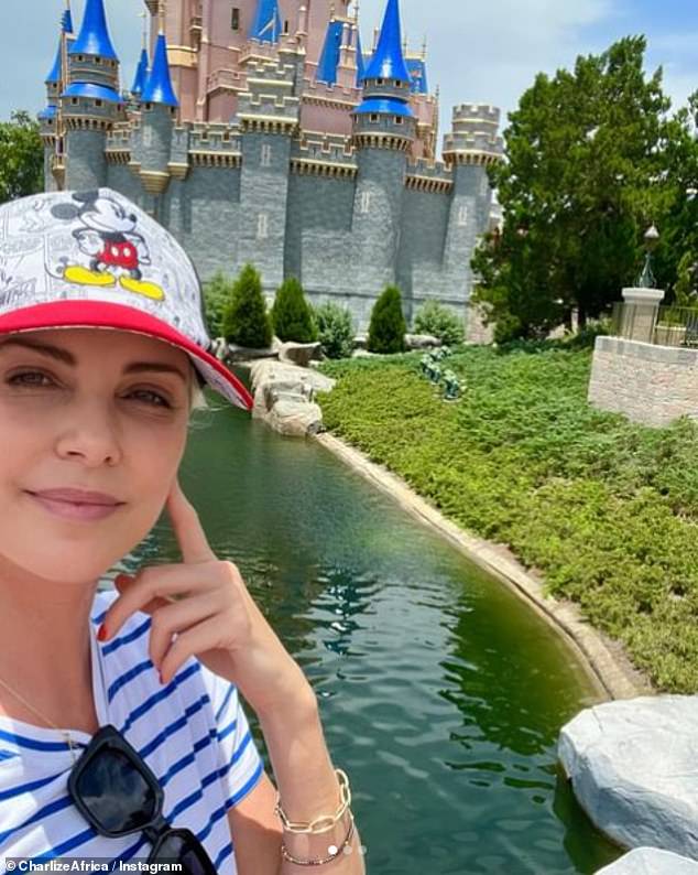 The South African-born beauty smiled in a selfie, showing off her Mickey Mouse hat and blue and white striped top.