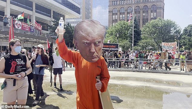 A protester appeared in an orange jumpsuit and a Donald Trump mask at the event.