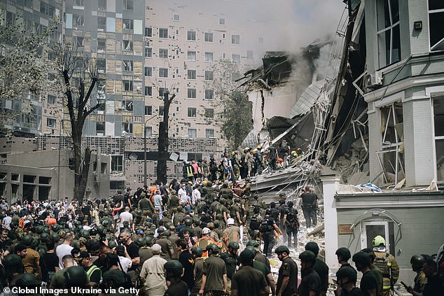 People clear debris from a building of one of Ukraine's largest children's hospitals, which was partially destroyed by a Russian missile attack on July 8, 2024 in kyiv, Ukraine.