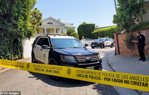 An LAFD official told ET that Simmons' body was not taken to a hospital due to his apparent natural death; police vehicles are seen outside Simmons' home.