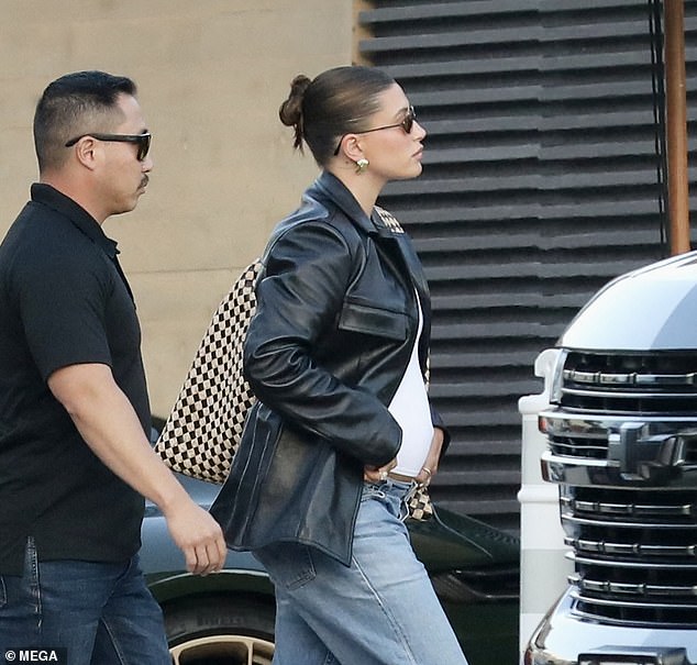 The model wore black, low, pointed heels, chunky earrings, black sunglasses and a large printed handbag.