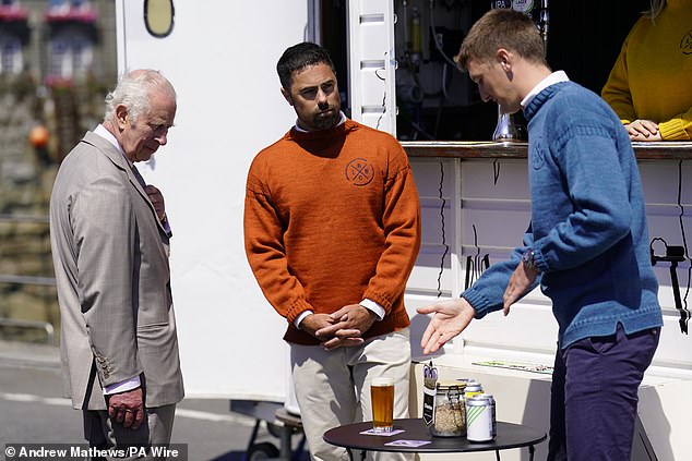 A Tuesday tipple? The King looks over a pint offered as part of a showcase of Guernsey's culture, heritage, agricultural produce and environmental initiatives at Crown Pier in St Peter Port