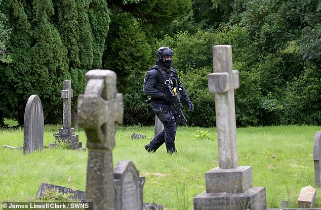 Clifford was found with serious injuries at Lavender Hill Cemetery in Enfield, north London. Pictured here, an armed police officer patrols the cemetery on Wednesday