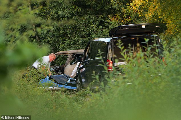 Officers can be seen moving plastic bags from inside the car at the scene.