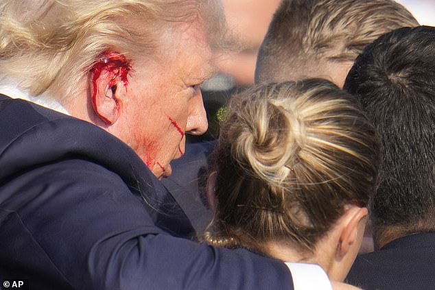 Trump is pictured above with a bloody ear following the shooting. He has since been shown with the ear wrapped in a bandage.