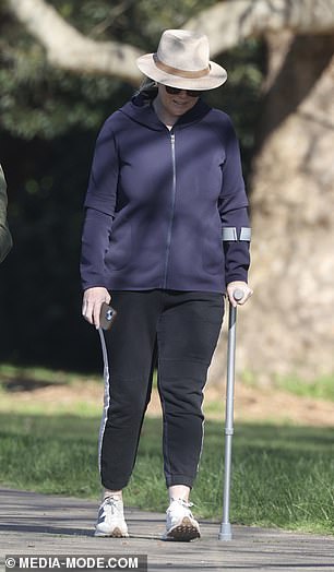 Samantha leaned on a metal crutch for support as she walked through the park.