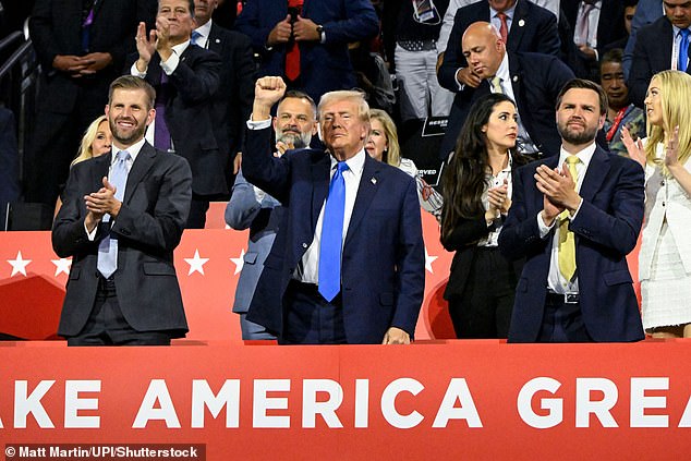 The crowd roars as Trump raises his fist alongside his son Eric and running mate JD Vance.