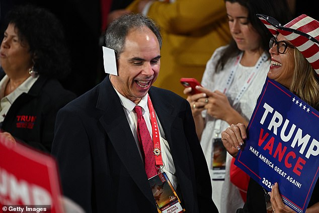 Trump's uniform of a navy blue suit, white shirt and red tie has a new accessory: the ear patch.