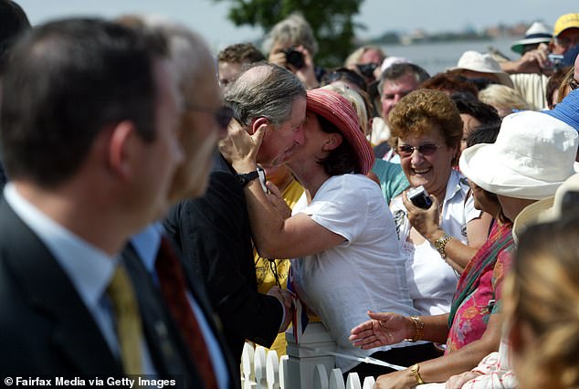 Prince Charles receives a kiss on the cheek from teacher Kate Skillman during his visit to Sydney, March 2005