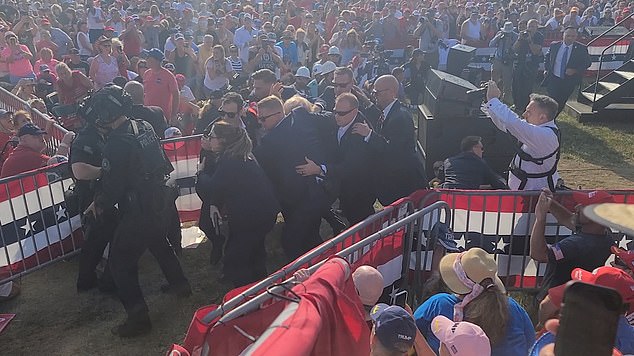 A team of at least nine Secret Service agents surrounded Trump as he was taken from the stage to his armored Chevrolet.