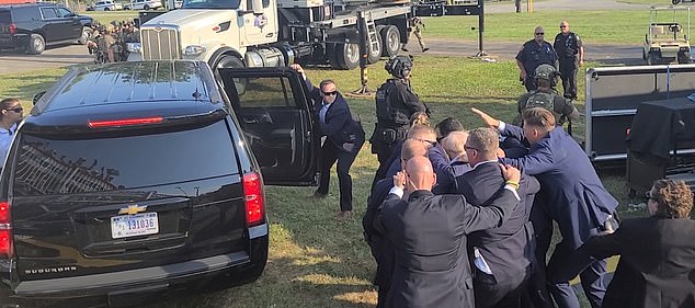 Without any other head protection, one officer was seen shielding the politician's head with only his bare hand, moments after he was shot in the ear.