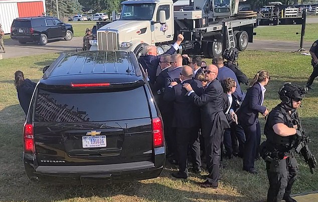 He defiantly raised a close-up in the air in a show of force that sent the crowd into a frenzy before he was sped away from the campaign rally.