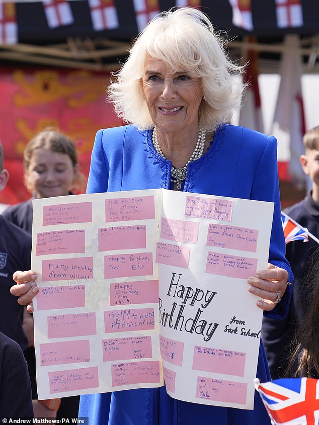 Queen Camilla beamed as she held a banner containing personalised happy birthday messages from pupils at Sark School in Guernsey.