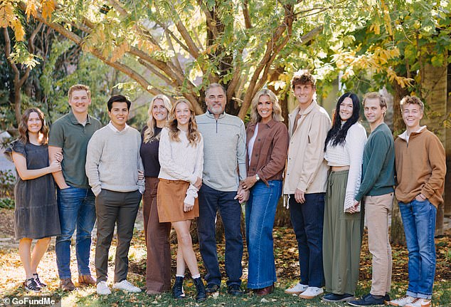 The couple appears in the photo surrounded by their six children, along with other family members.