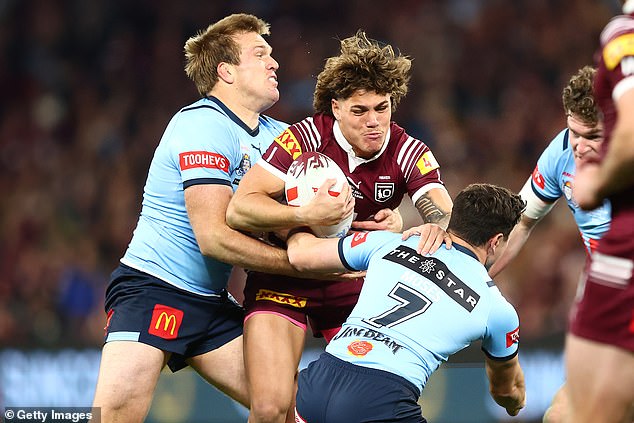 On Wednesday night, the Wolverine star was delighted with the result on his Instagram story and showed his support for the Blues as he watched the match on TV. Pictured: Queensland Maroons' Reece Walsh is tackled by NSW Blues' Jake Trbojevic