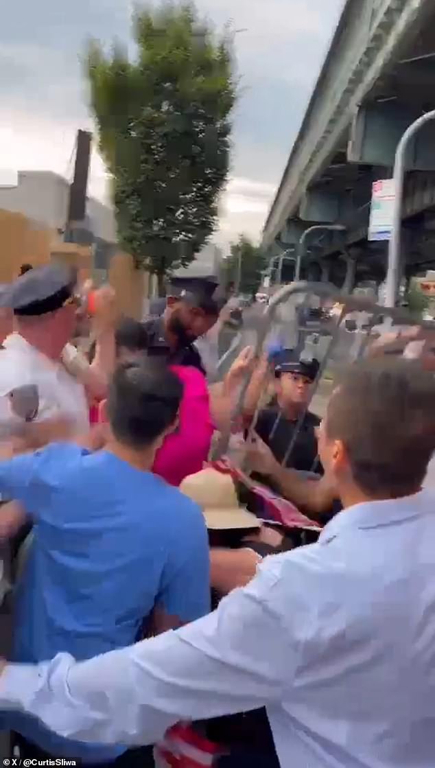 Barricades can be seen in the air as protesters fight with Zhuang seen in pink.