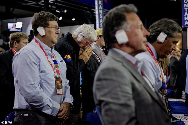 Delegates at the Republican National Convention in Milwaukee, Wisconsin, place homemade bandages on their ears.