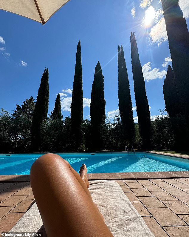 In one image, the singer flaunted her tanned sideburns as she relaxed on a sun lounger by a pool at the villa, with one of her feet on display.