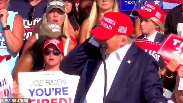 Republican presidential candidate and former US President Donald Trump reacts after gunshots were heard during a campaign rally