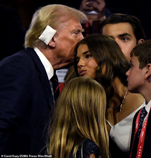 Donald Trump gives his 17-year-old granddaughter Kai Madison Trump a kiss on the head after his remarks at the Republican National Convention on Wednesday night.