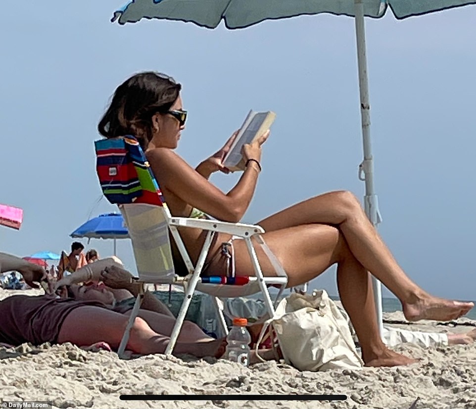 Dressed in a tiny brown bikini, she looked relaxed and carefree as she lounged on the sand, reading, tanning and napping.