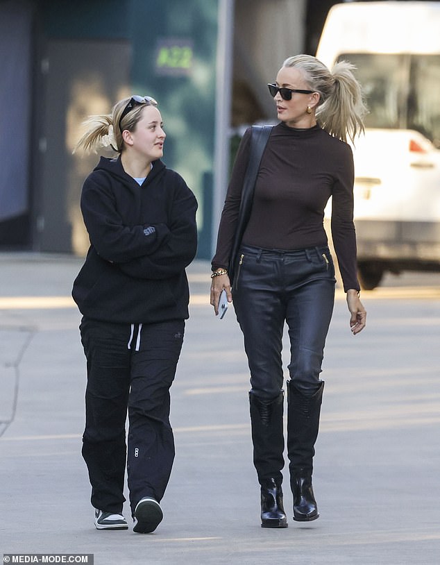 The mother of one completed the ensemble with a burgundy long-sleeved blouse and a pair of Ray-Ban sunglasses.