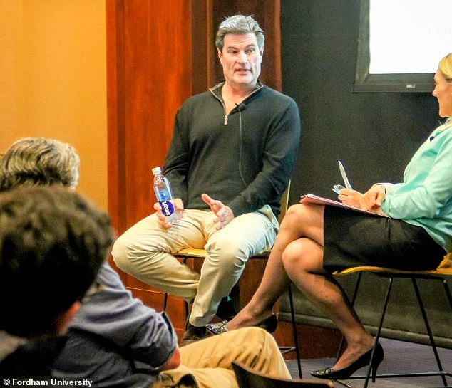 Cline is seen participating in a discussion with business students at Fordham University.