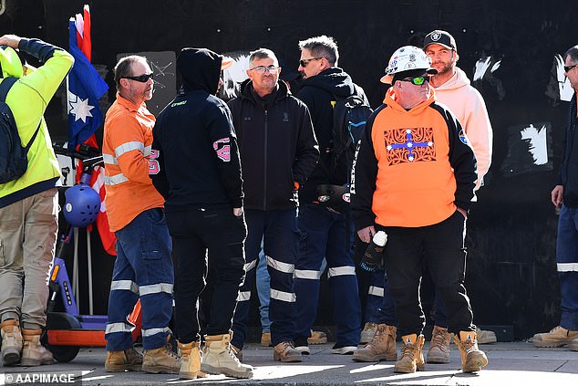 CFMEU union members stage a protest to prevent access to a construction site in Brisbane, above