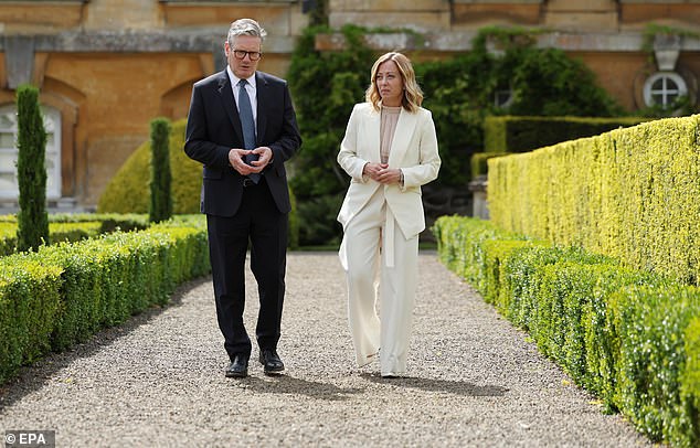 British Prime Minister Keir Starmer (L), who is 1.73m tall, and Italian Prime Minister Giorgia Meloni (R), who is 1.60m tall, walk outdoors at the European Political Community (EPC) summit