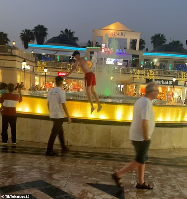 He jumped into the fountain from the edge of the pond before being dragged away by a staff member and then a security guard.