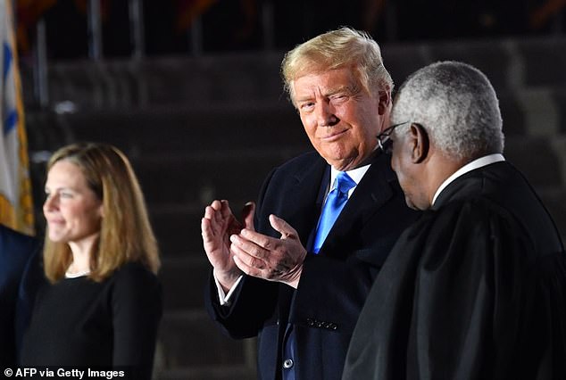 U.S. President Donald Trump applauds alongside Supreme Court Associate Justice Clarence Thomas and Judge Amy Coney Barrett, who was just sworn in as an Associate Justice of the U.S. Supreme Court, during a ceremony on the South Lawn of the White House on October 26, 2020, in Washington, DC.