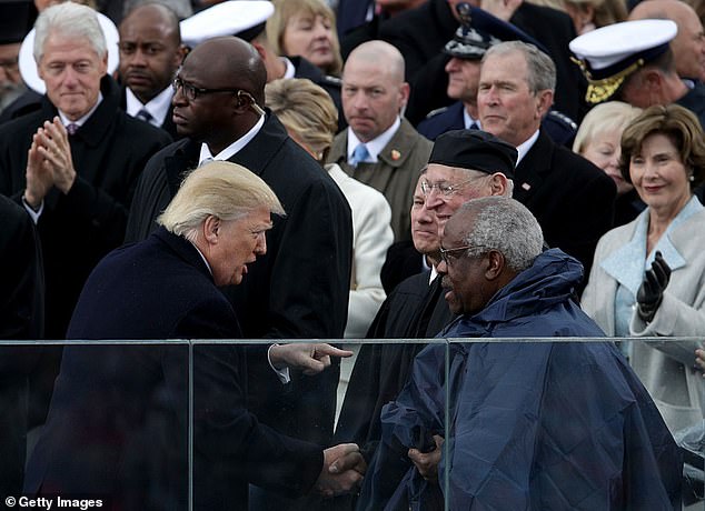 President Donald Trump shakes hands with Supreme Court Justice Clarence Thomas on the West Front of the U.S. Capitol on January 20, 2017.