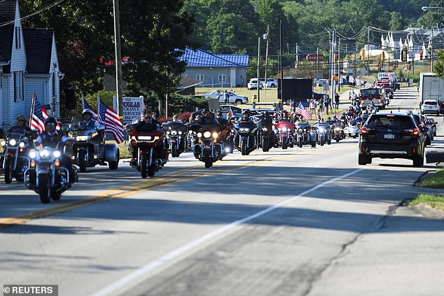 People ride motorcycles during an emergency vehicle procession through Sarver, Pennsylvania, carrying the casket with the body of Corey Comperatore