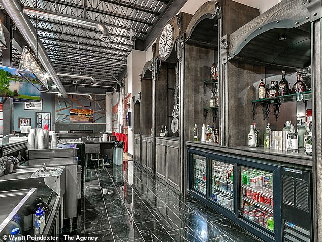 Pictured: One of the kitchens, featuring a futuristic black-and-white design with a silver-textured backsplash, black cabinets and white marble countertops.