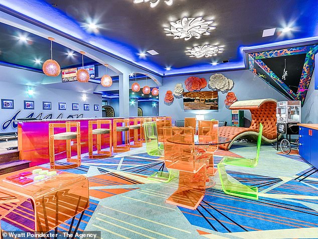 One of the most colorful rooms in the house is the bowling alley, which features clear neon furniture, a fun patterned floor, and cool lighting.