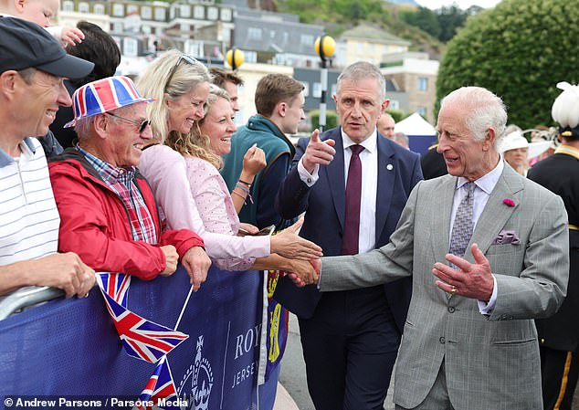 A member of royal security urges the King to move on as he is taken to safety.