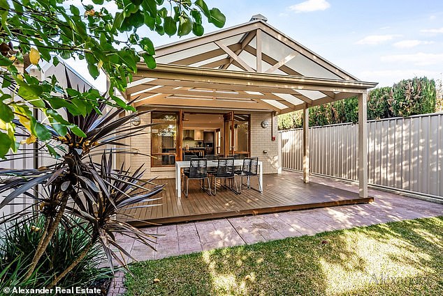 Located just 4km from the CBD, the two-storey apartment features a beautiful open-plan layout and charming wood finishes. Pictured: the charming porch entertaining area