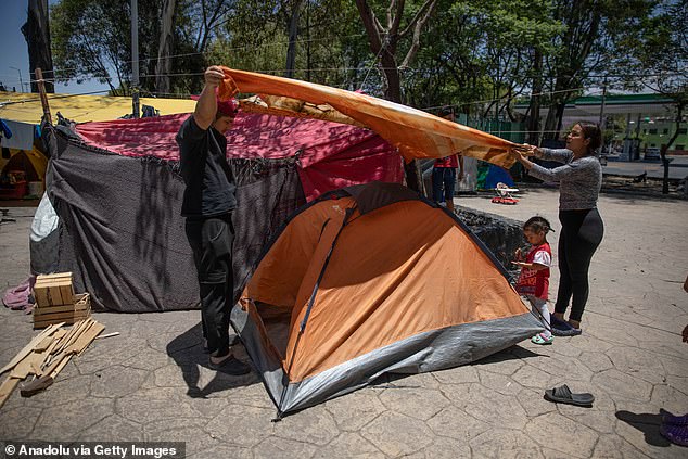 A Venezuelan migrant and his wife set up a tent at a makeshift shelter camp on the median strip of Eje Central Avenue in Mexico City, Mexico, on June 18.